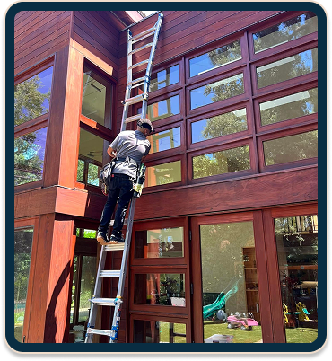 Man cleaning windows standing on staircase